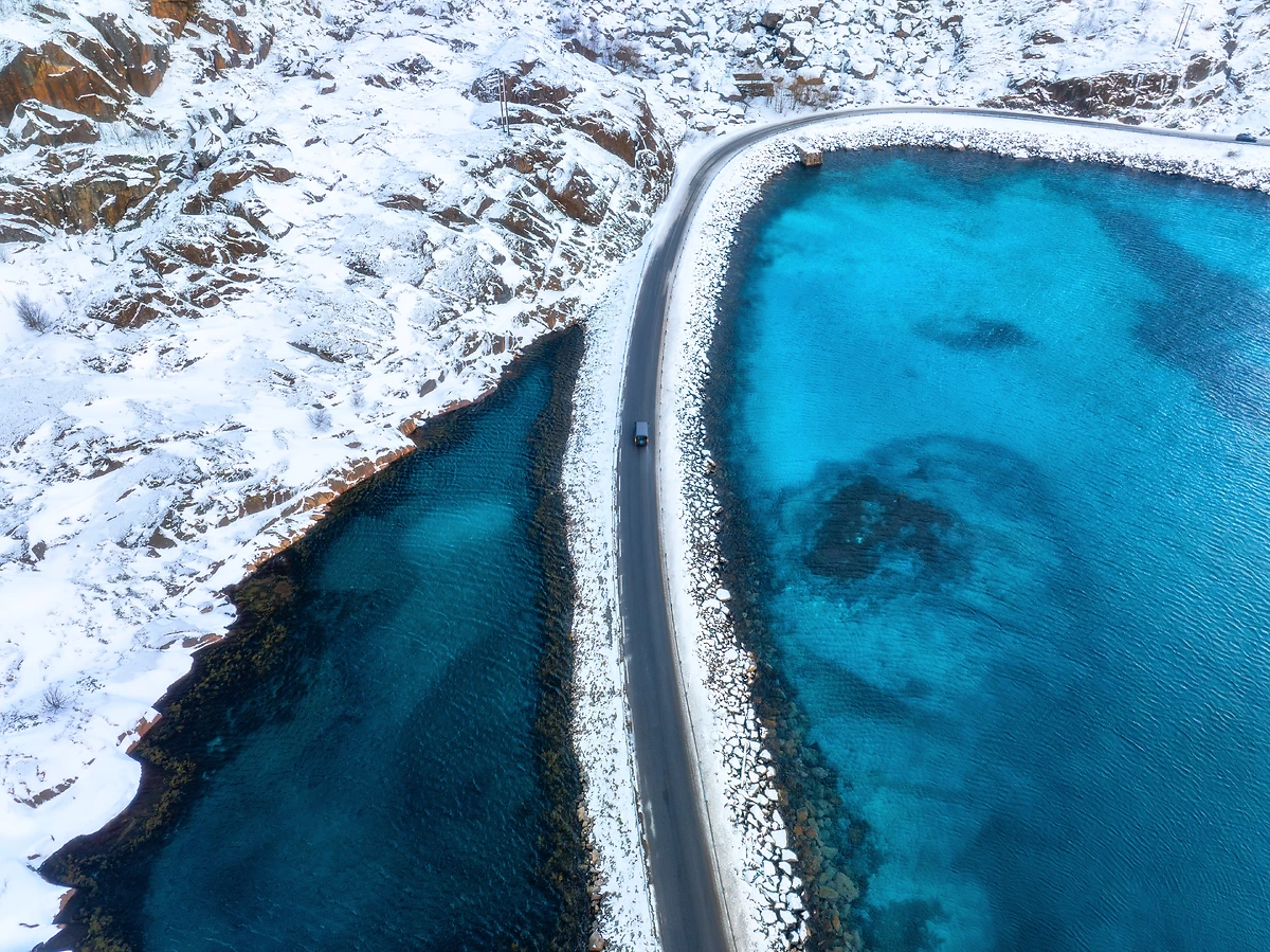 Vue aérienne de la route enneigée vers le Henningsvaer, îles Lofoten, Norvège